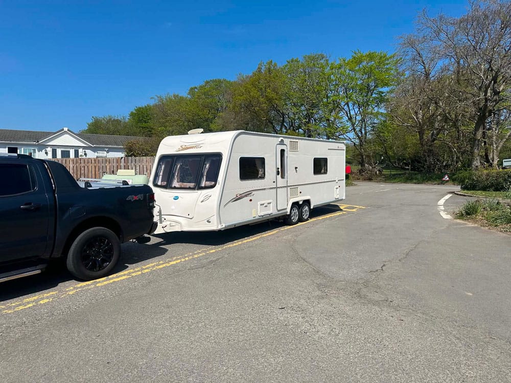 Bailey Senator twin-axle touring caravan hitched to a pickup truck on a sunny day